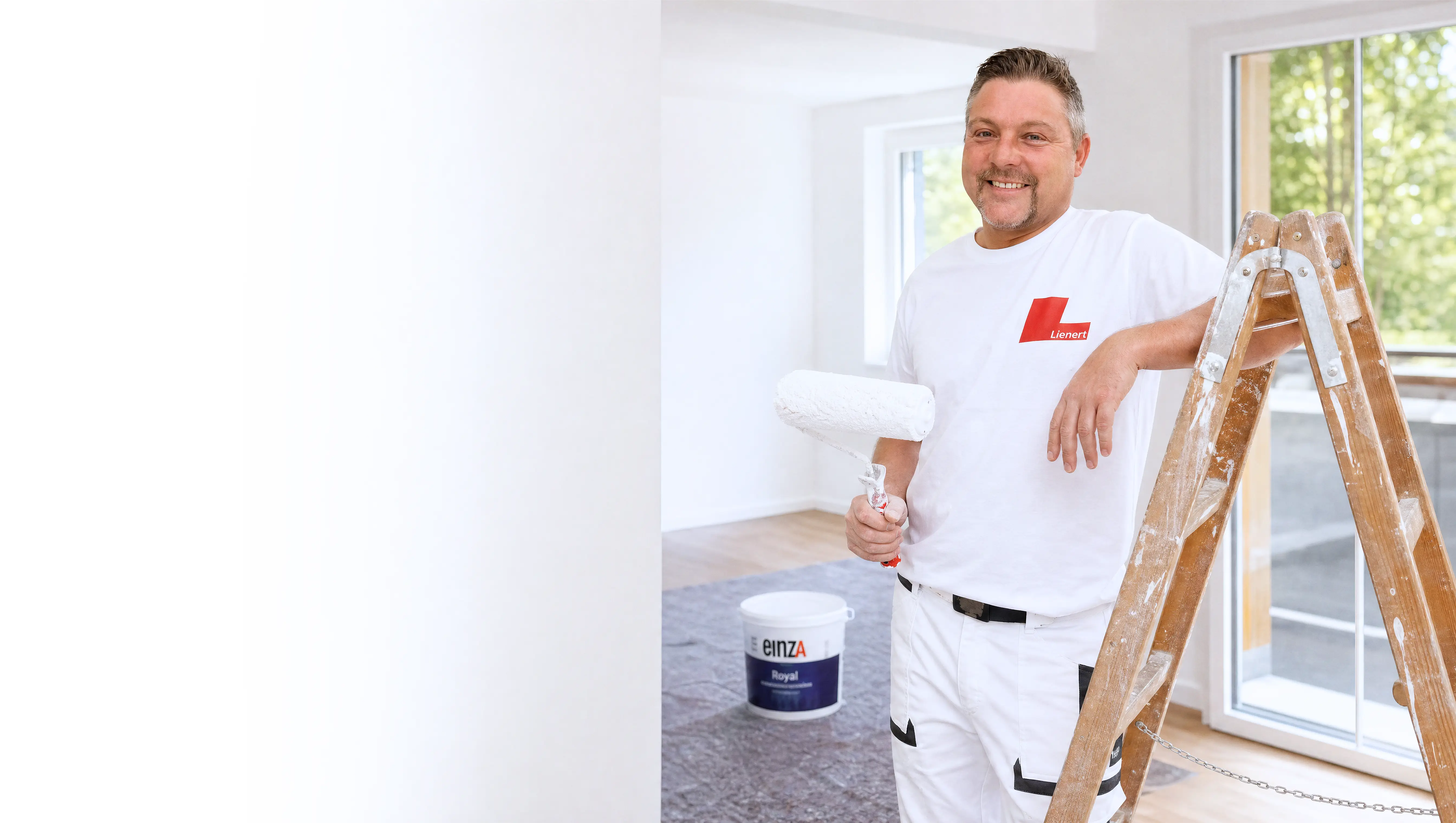 Tobias Lienert mit Farbrolle in einem frisch renovierten Raum